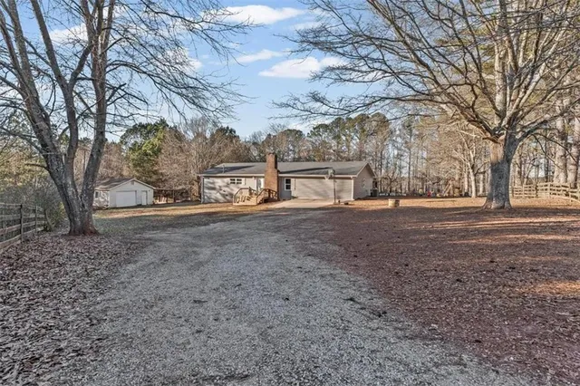 a view of dirt yard with a large tree