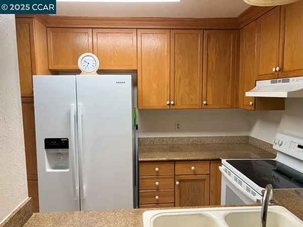 a bathroom with a granite countertop sink and a toilet