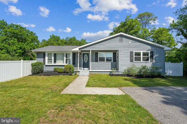 a front view of a house with yard patio and green space
