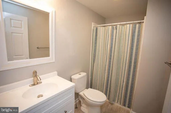 a bathroom with a toilet a sink and a mirror