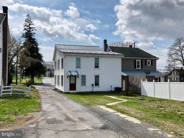 a view of a house with a yard and large tree