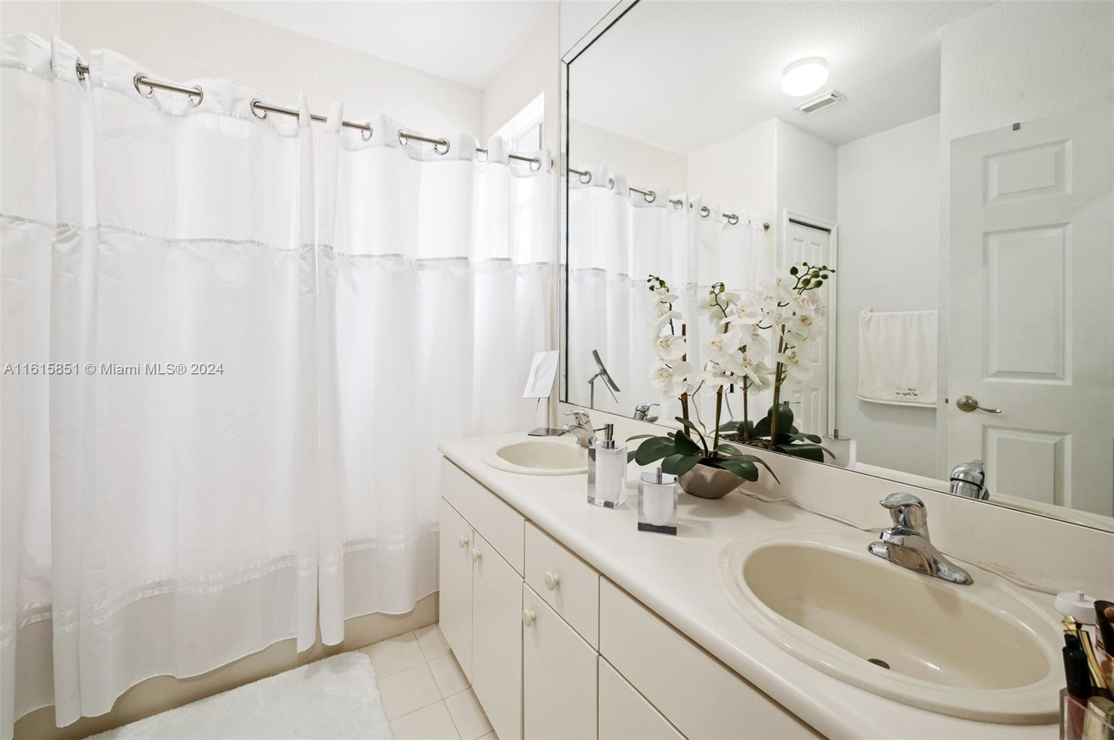 24044 Southwest 107th Court Homestead, FL 33032 - Photo 14 of 26 a bathroom with a double vanity sink and mirror