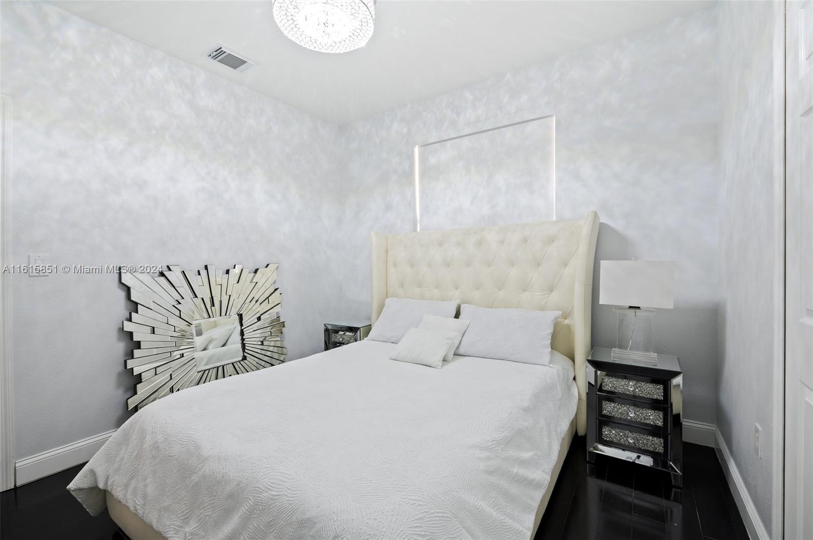 24044 Southwest 107th Court Homestead, FL 33032 - Photo 16 of 26 a bedroom with a bed and a painting on the wall