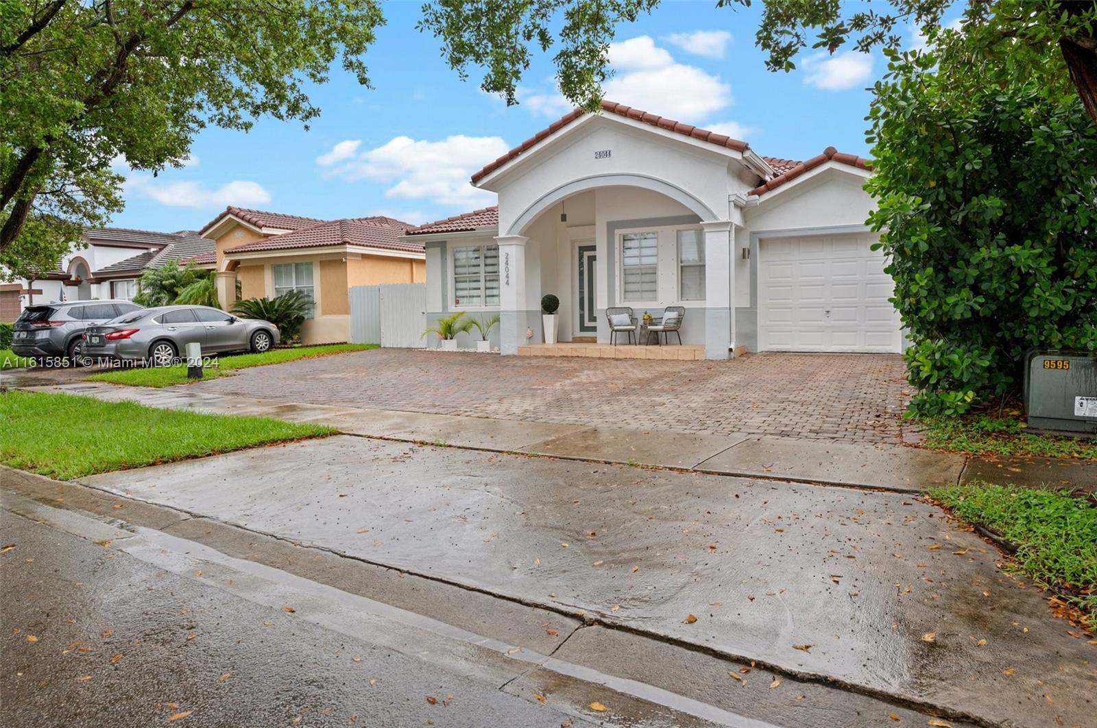 24044 Southwest 107th Court Homestead, FL 33032 - Photo 2 of 26 a front view of a house with a yard and garage