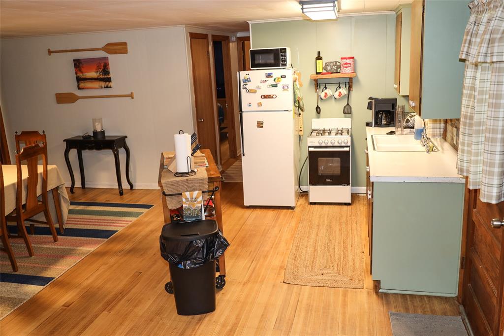 841 Dogwood Trail Logansport, LA 71049 - Photo 14 of 40 a kitchen with stainless steel appliances a stove top oven a refrigerator a dining table and chairs with wooden floor