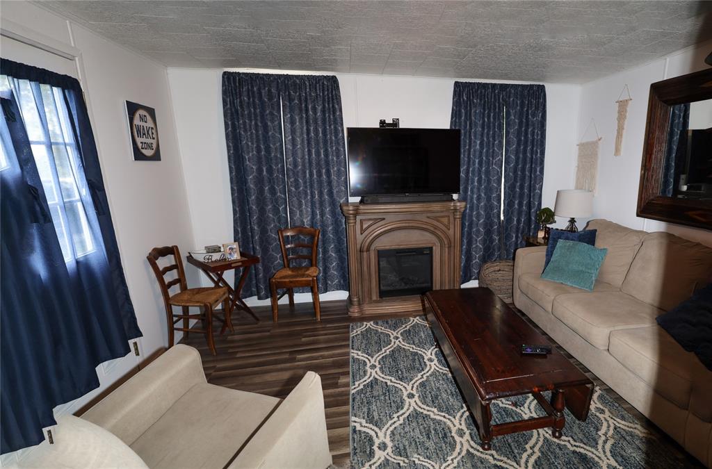 841 Dogwood Trail Logansport, LA 71049 - Photo 8 of 40 a living room with furniture a fireplace and a flat screen tv