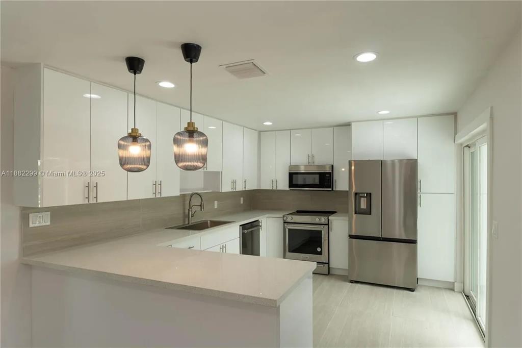 11872 Southwest 196th Terrace Miami, FL 33177 - Photo 3 of 15 a kitchen with kitchen island a counter top space stainless steel appliances and cabinets