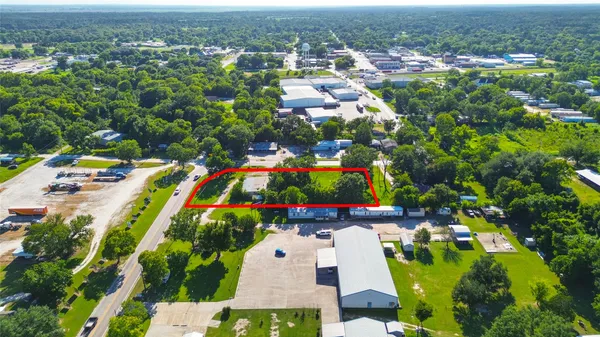 an aerial view of residential houses with outdoor space and trees