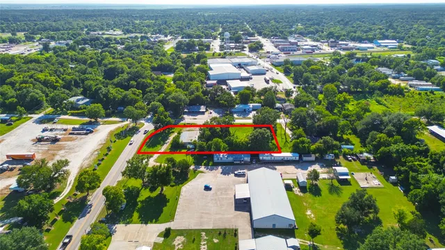 an aerial view of residential houses with outdoor space and trees