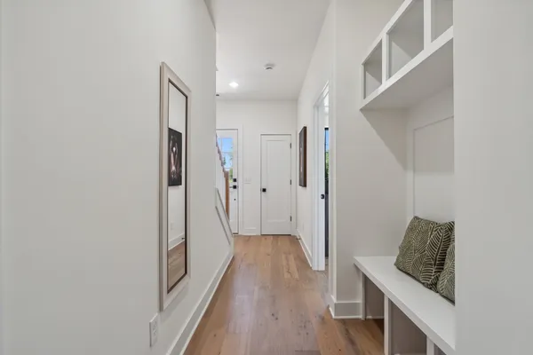a view of a hallway with wooden floor and staircase