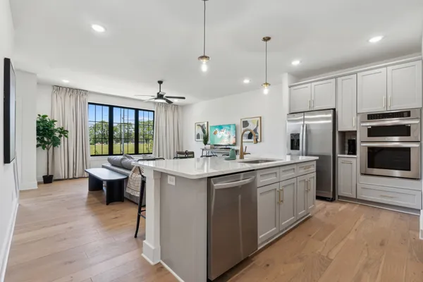 a kitchen with a sink stove and wooden floor