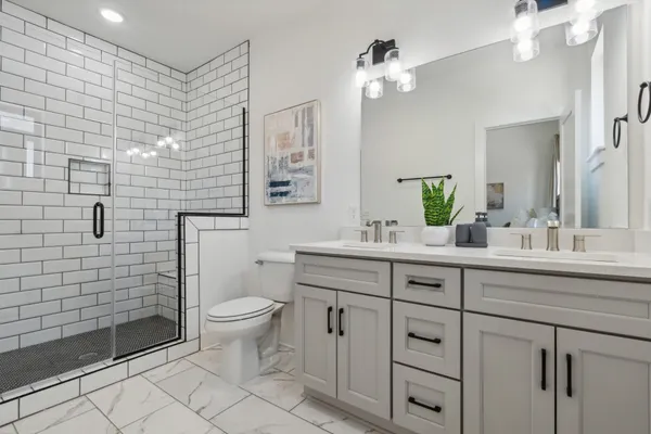 a bathroom with a double vanity sink mirror and toilet