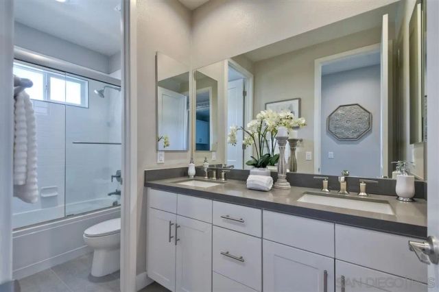a bathroom with a double vanity sink toilet and shower