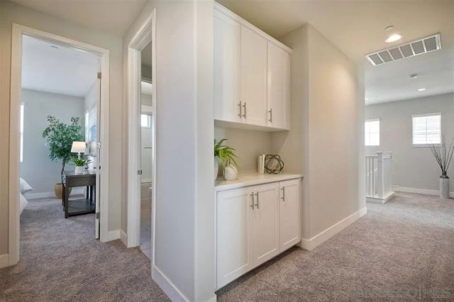 a kitchen with white cabinets and sink