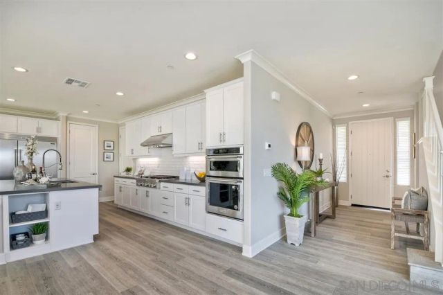 a kitchen with stainless steel appliances a white stove top oven and a hard wood floor