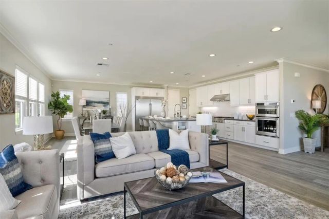 a living room with furniture kitchen and a table