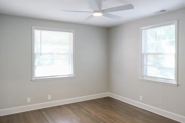 an empty room with a window and wooden floor