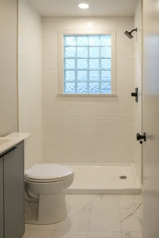 a bathroom with a toilet and a shower