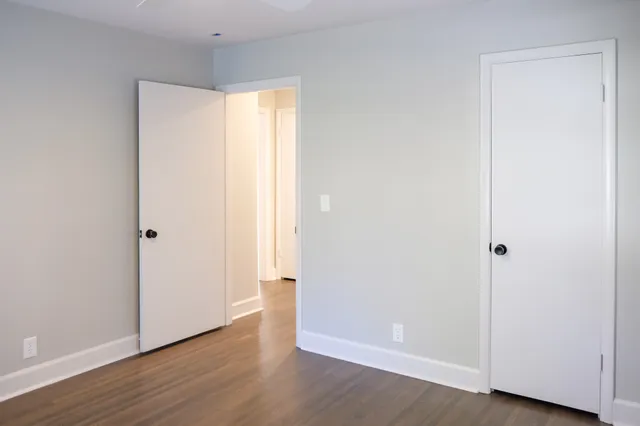 an empty room with wooden floor and closet