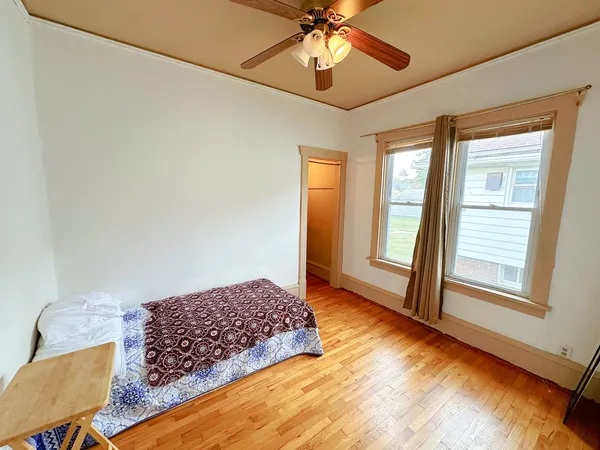 a bedroom with bed and wooden floor