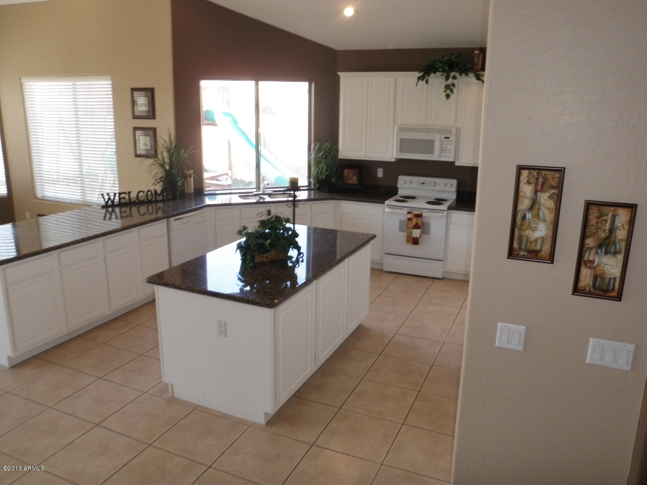 3672 South Martingale Road Gilbert, AZ 85297 - Photo 7 of 45 a kitchen with stainless steel appliances a sink a stove a refrigerator cabinets and a window