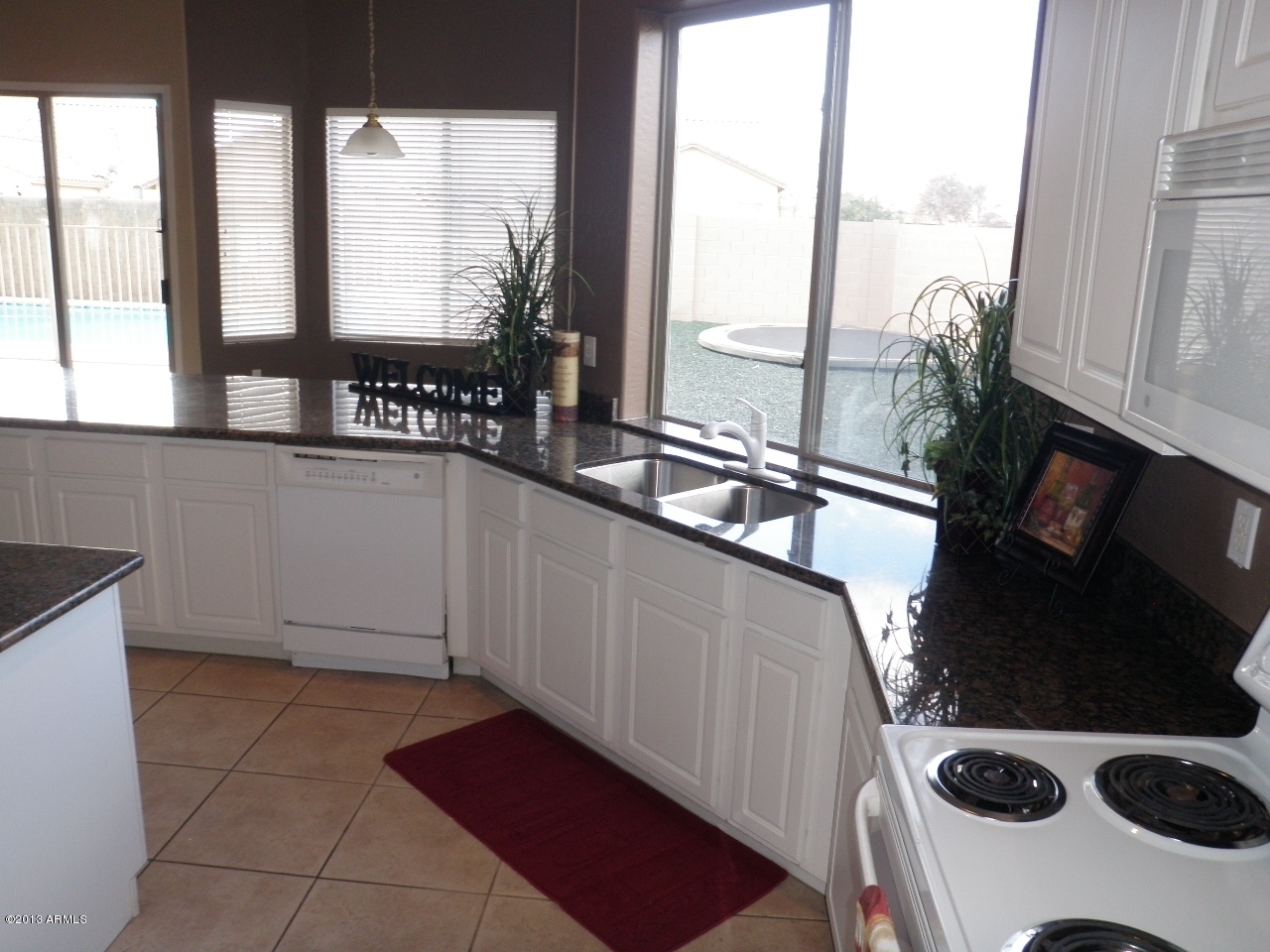 3672 South Martingale Road Gilbert, AZ 85297 - Photo 10 of 45 a kitchen with a sink a stove and a refrigerator