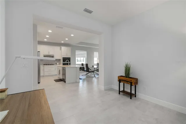 a living room with furniture and a kitchen area