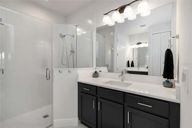 a bathroom with a double vanity sink mirror and shower