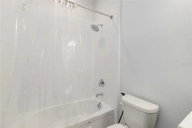 a white bath tub sitting next to a white toilet and a shower