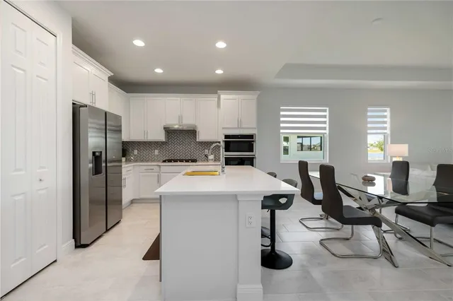a kitchen with stainless steel appliances kitchen island granite countertop a refrigerator and microwave