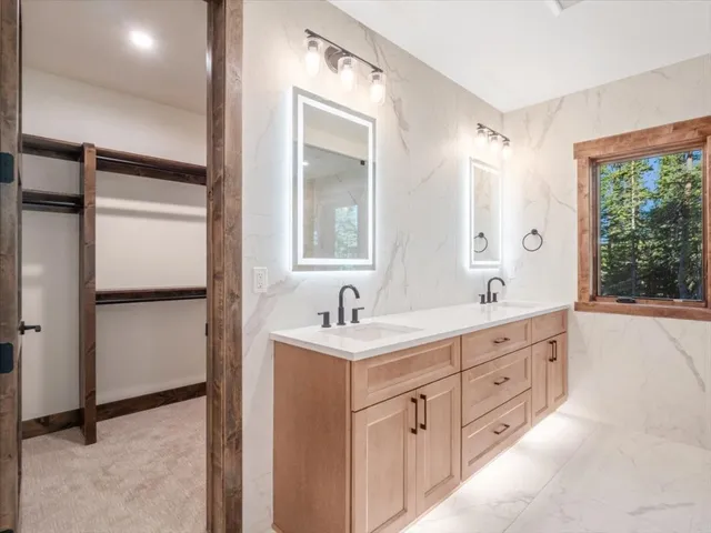 a bathroom with a granite countertop sink mirror and a bathtub