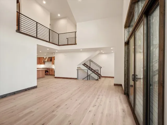 a view of a hallway with wooden floor and staircase