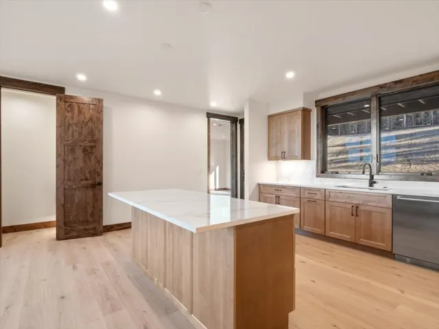 a kitchen with stainless steel appliances granite countertop a sink and a refrigerator
