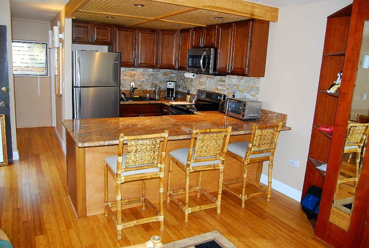 a kitchen with stainless steel appliances granite countertop a refrigerator and a stove top oven