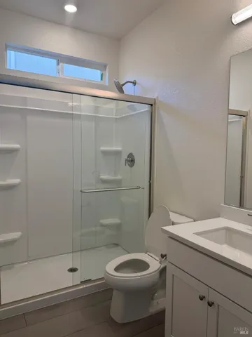 a bathroom with a sink a toilet and shower