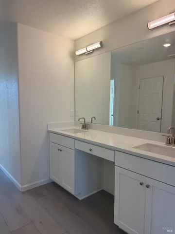 a bathroom with a double vanity sink and mirror