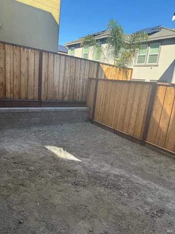 a view of a backyard with wooden fence