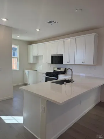 a kitchen with sink a microwave a stove and cabinets