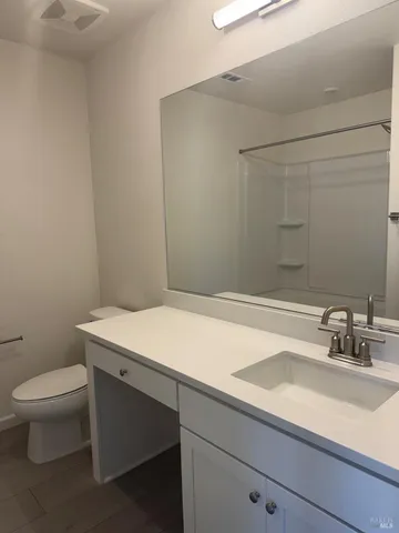 a bathroom with a sink a toilet and a mirror