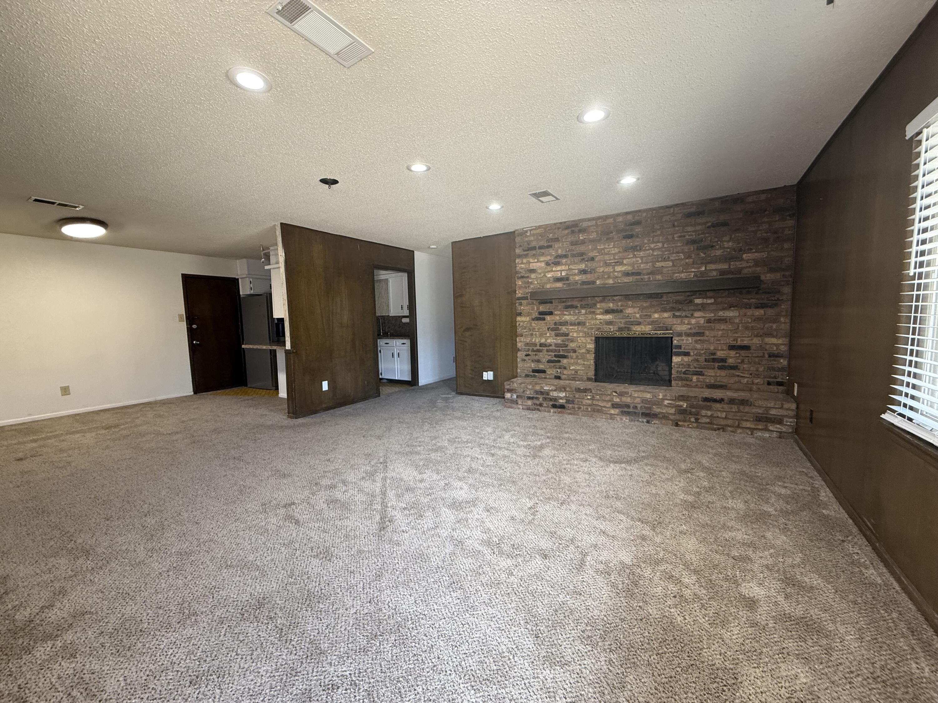 4425 75th Drive, Unit B Lubbock, TX 79424 - Photo 3 of 10 an empty room with furniture and a fireplace