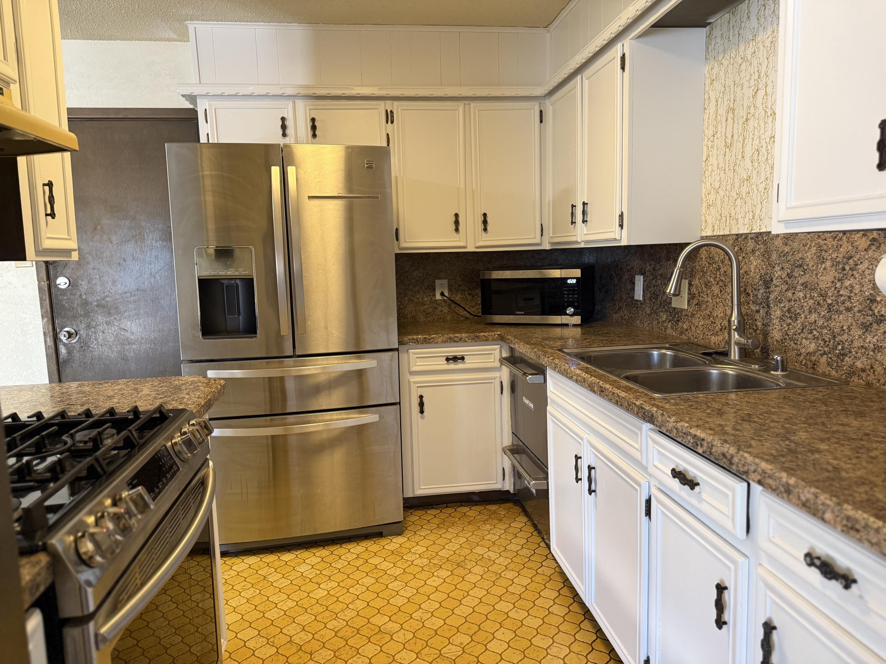 4425 75th Drive, Unit B Lubbock, TX 79424 - Photo 6 of 10 a kitchen with granite countertop a refrigerator stove and sink
