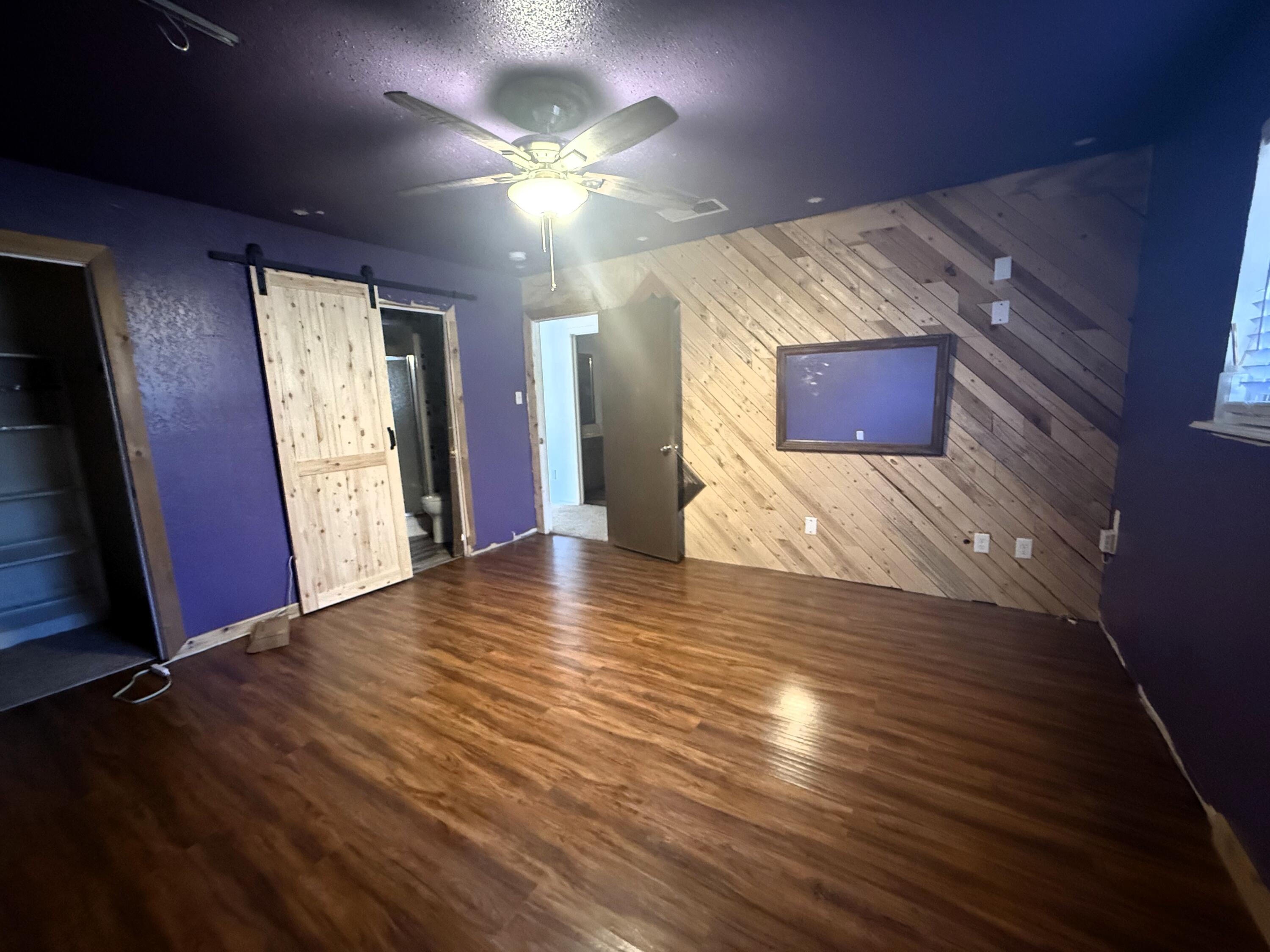 4425 75th Drive, Unit B Lubbock, TX 79424 - Photo 7 of 10 a view of an empty room with window and wooden floor