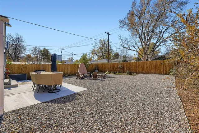 a view of a backyard with table and chairs with wooden fence