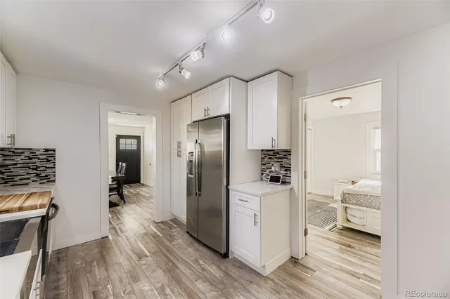 a view of a kitchen with a refrigerator and wooden floor