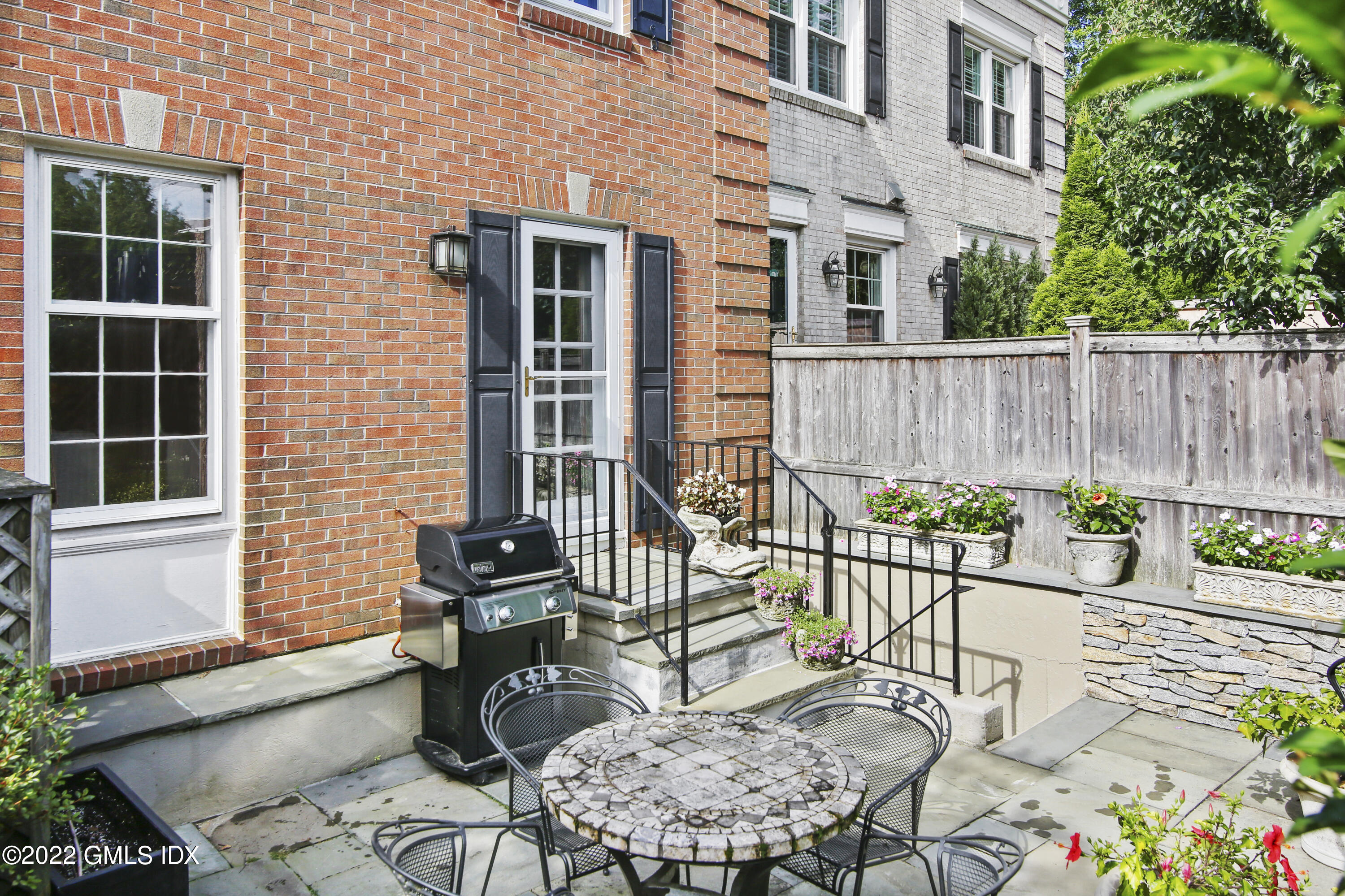 155 Field Point Road, Unit 2N Greenwich, CT 06830 - Photo 14 of 19 a view of a chair and table in the back yard of the house