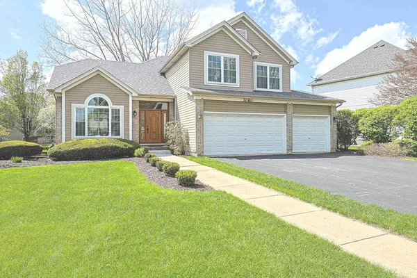 a front view of a house with a yard and garage