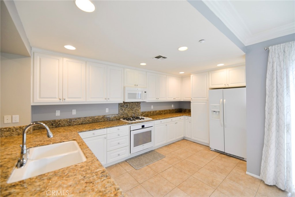 24 Paseo Rosa San Clemente, CA 92673 - Photo 11 of 35 a kitchen with stainless steel appliances granite countertop a sink a stove and a refrigerator