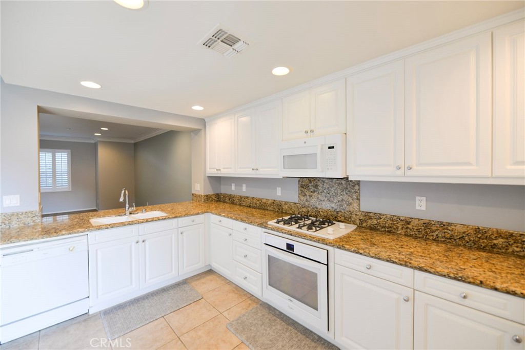 24 Paseo Rosa San Clemente, CA 92673 - Photo 10 of 35 a kitchen with granite countertop a sink a stove and cabinets