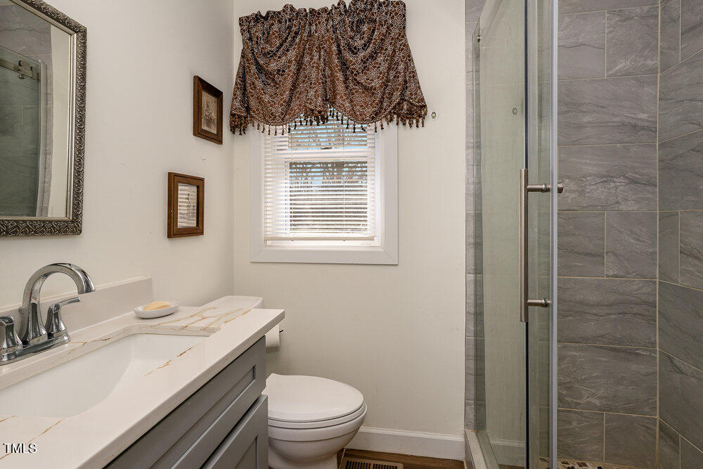 810 Grovemont Road Raleigh, NC 27603 - Photo 20 of 23 a bathroom with a granite countertop sink toilet and shower
