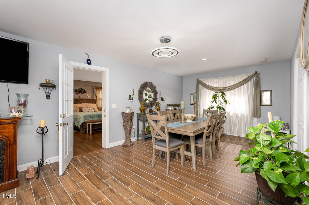 810 Grovemont Road Raleigh, NC 27603 - Photo 10 of 23 a dining room with furniture potted plants and wooden floor